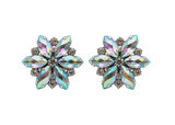 Pair of flower-shaped earrings with multicolored gemstones on a light gray background