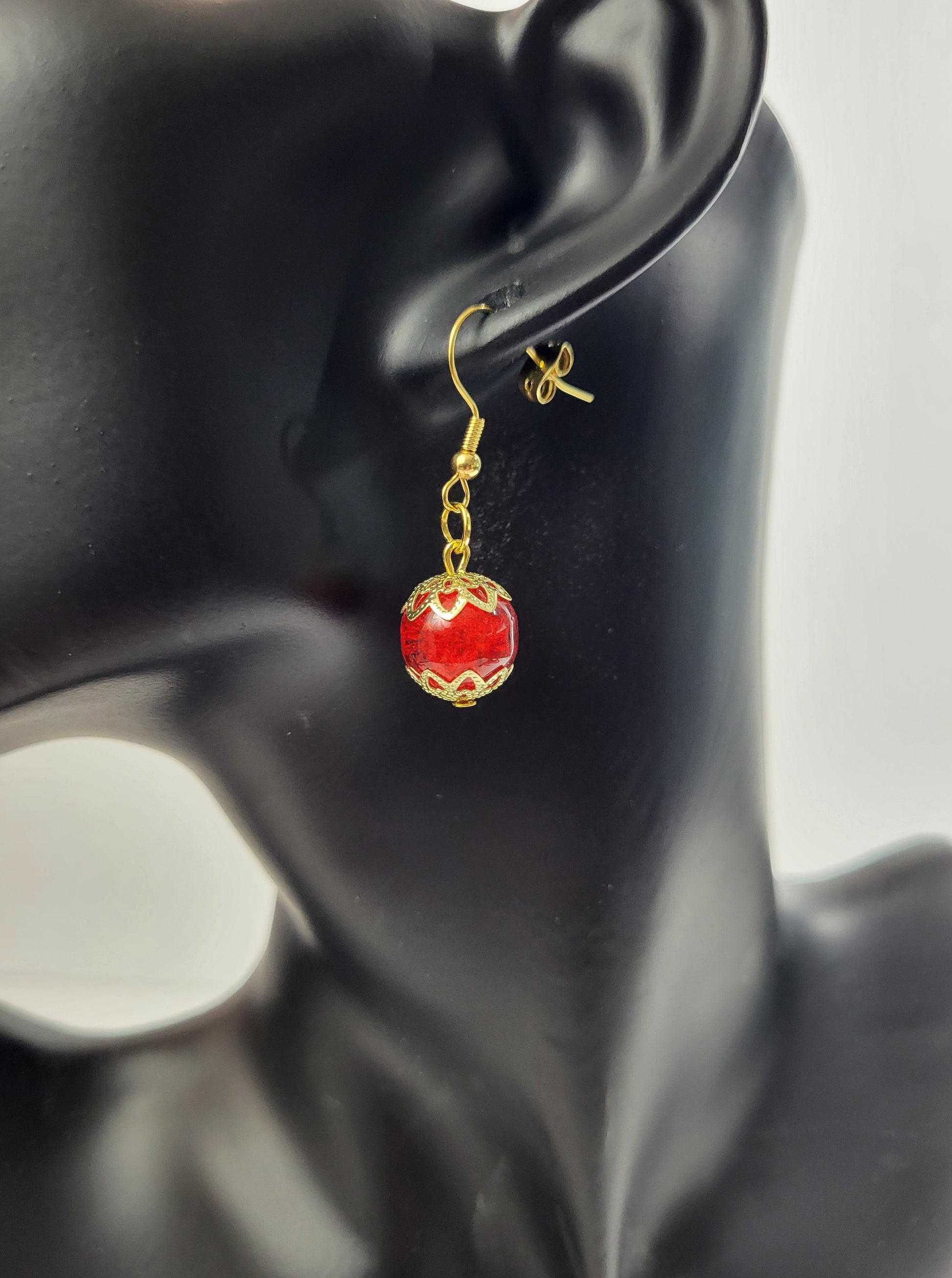 Introducing Ruby Droplet Earrings – a striking blend of passion and elegance that adds a touch of glamour to your ensemble. These exquisite earrings feature captivating red glass beads, each carefully crafted to resemble a radiant ruby. The rich red hue, coupled with delicate gold accents, creates a dazzling combination that is both bold and timeless.