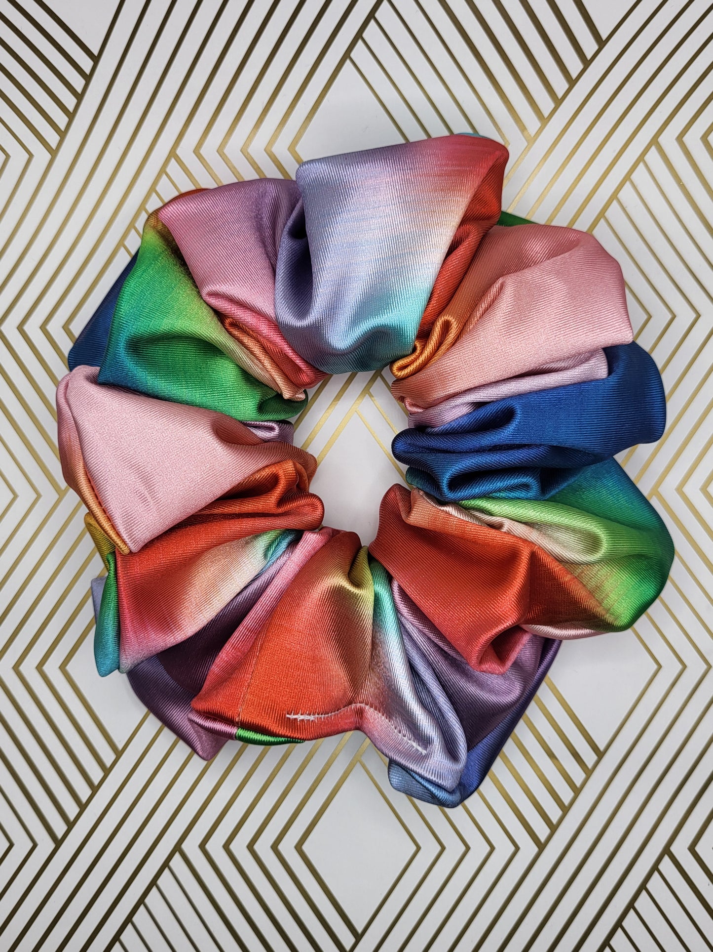 Introducing the Evangeline Chibi XXL Oversize Scrunchie, a vibrant accessory designed to make a bold statement. This oversized scrunchie features a stunning blend of rainbow colors, adding a playful and energetic touch to your hairstyle.