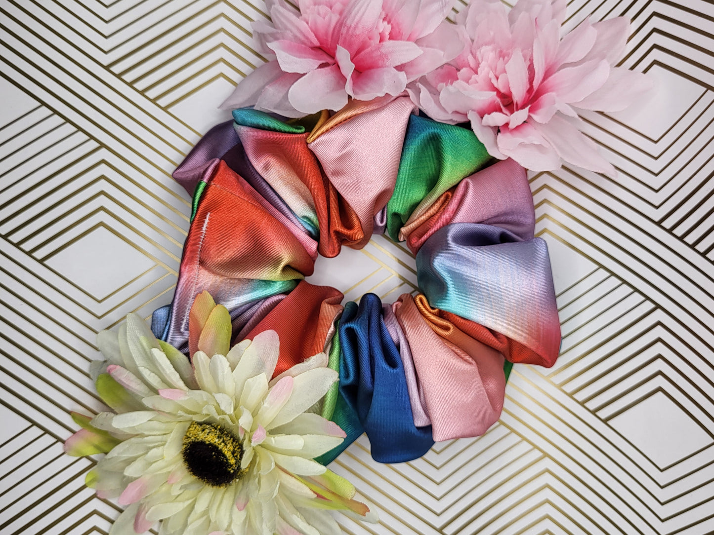 Introducing the Evangeline Chibi XXL Oversize Scrunchie, a vibrant accessory designed to make a bold statement. This oversized scrunchie features a stunning blend of rainbow colors, adding a playful and energetic touch to your hairstyle.