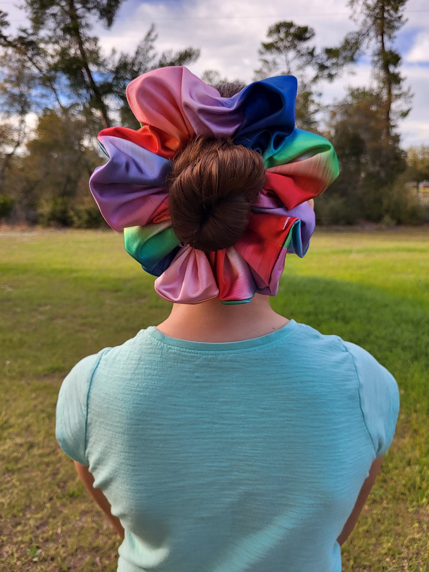 Introducing the Evangeline Chibi XXL Oversize Scrunchie, a vibrant accessory designed to make a bold statement. This oversized scrunchie features a stunning blend of rainbow colors, adding a playful and energetic touch to your hairstyle.