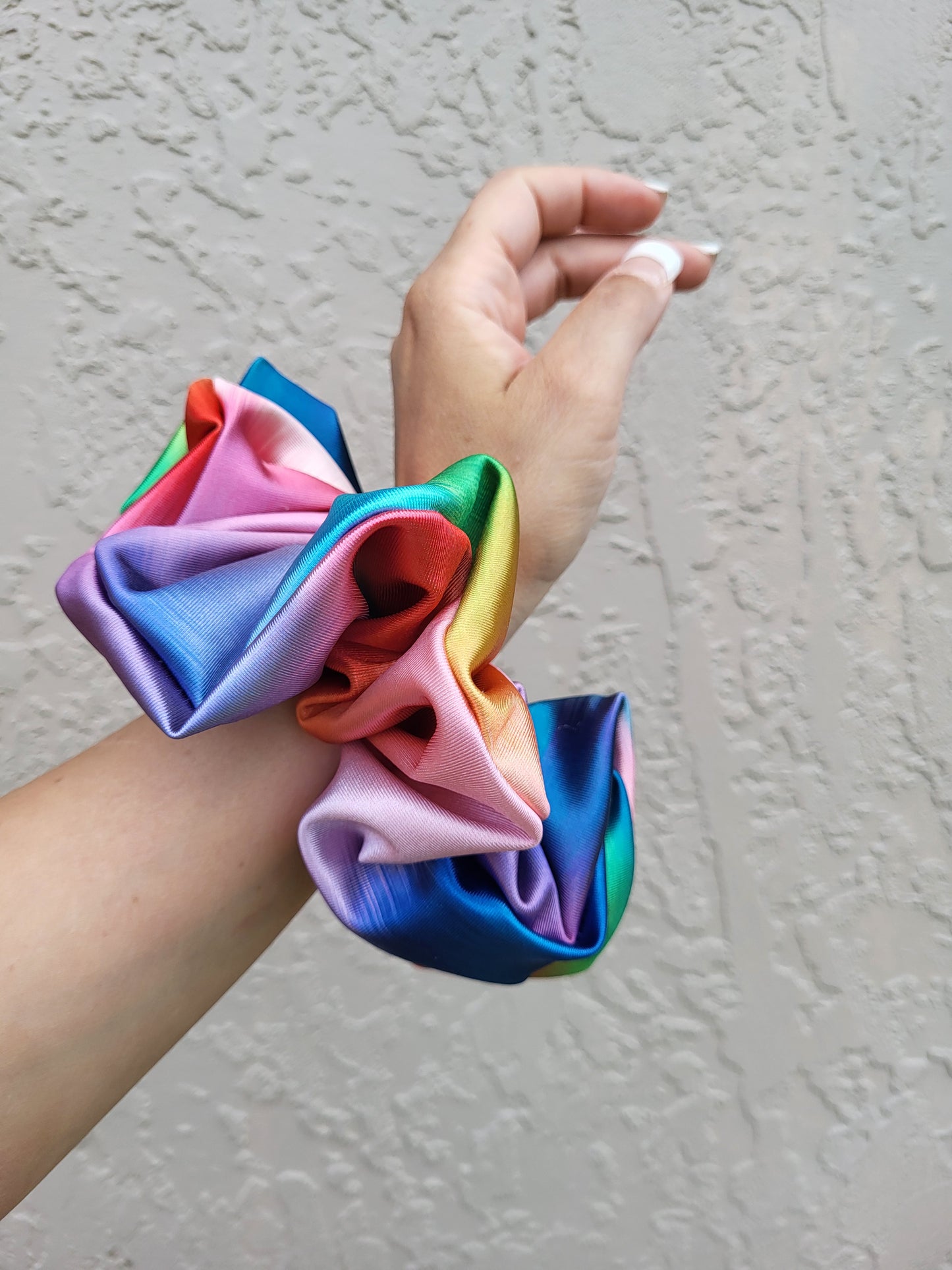 Introducing the Evangeline Chibi XXL Oversize Scrunchie, a vibrant accessory designed to make a bold statement. This oversized scrunchie features a stunning blend of rainbow colors, adding a playful and energetic touch to your hairstyle.