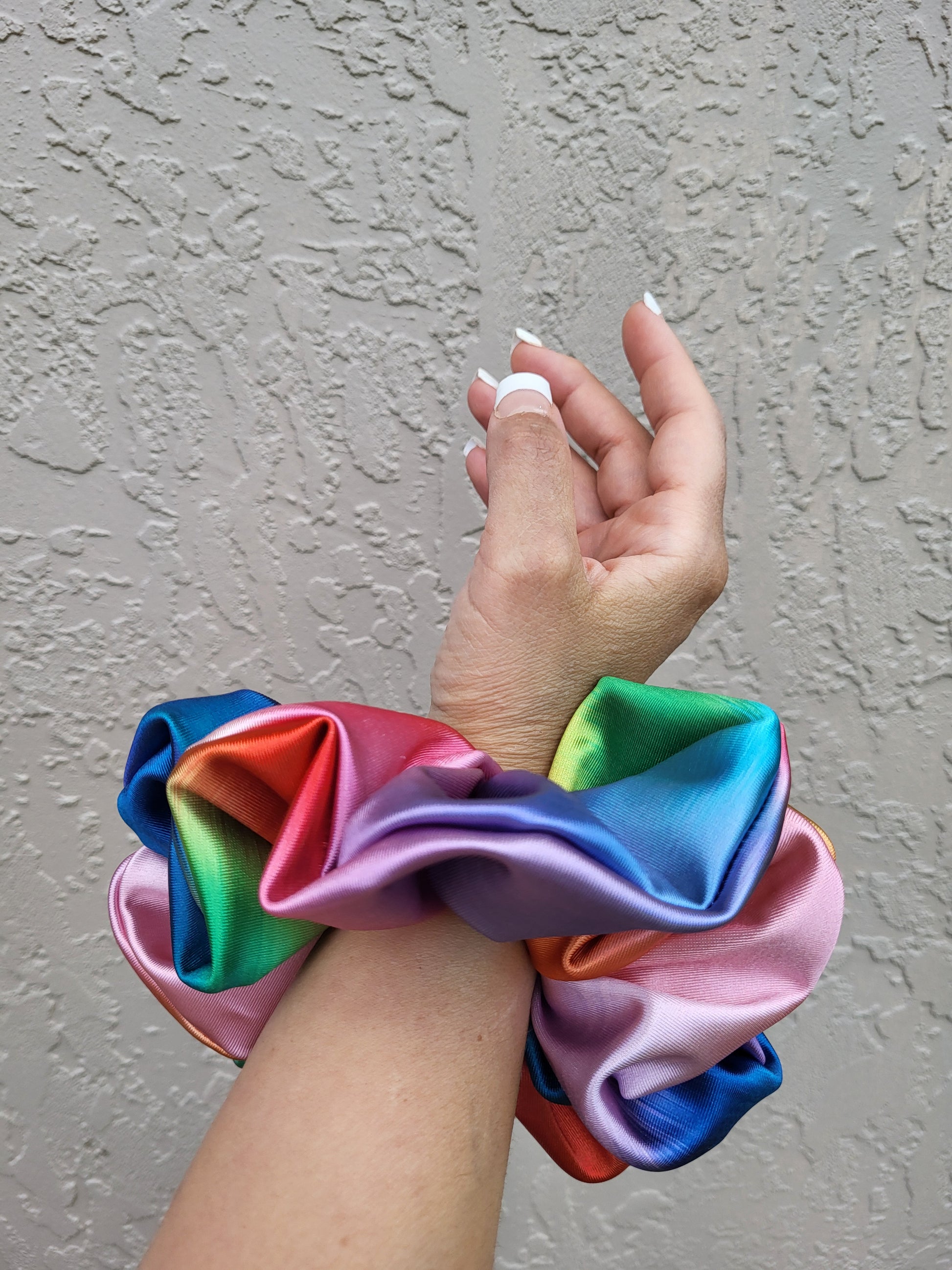 Introducing the Evangeline Chibi XXL Oversize Scrunchie, a vibrant accessory designed to make a bold statement. This oversized scrunchie features a stunning blend of rainbow colors, adding a playful and energetic touch to your hairstyle.