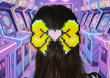 Person with a pixelated bow in a retro arcade setting with neon lights and star decorations.