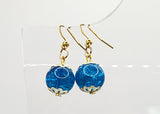 Blue glass earrings with gold hooks on a white background