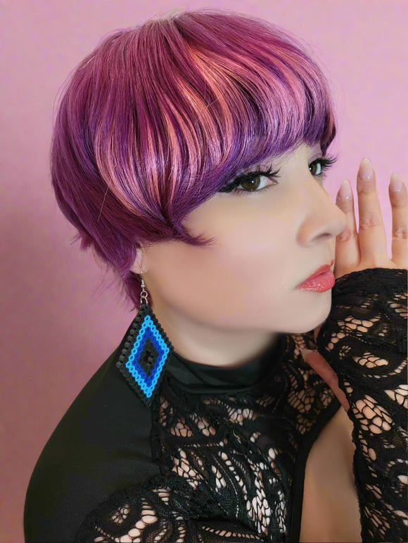 Person with vibrant purple hair wearing a black lace top and blue earrings.