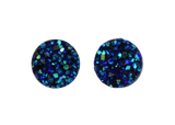 Pair of round blue glittery earrings on a white background