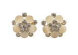 Pair of floral earrings with beige flowers and gold accents on a white background