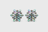 Pair of flower-shaped earrings with multicolored gemstones on a light gray background