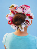 Person wearing a colorful hair bun cover against a blue background