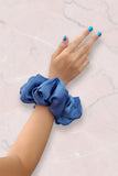 a blue scrunchie worn around wrist
