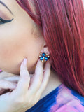 a woman with reddish brown hairwearing blue faux pearl earrings