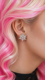 Close-up of a person with pink hair wearing a sparkling earring called starlight empress studs.