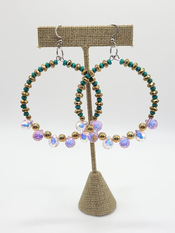 two beaded hoop earrings hanging on earring display