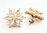 Gold earrings with star-shaped and bar designs on a white background