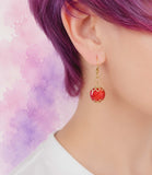 Red earring on a model with a blurred colorful background