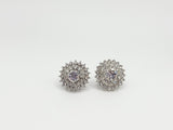 Pair of silver earrings with purple gemstones on a white background